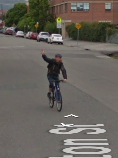 Google-StreetView image of Lasse Scherfig on a bike. Near the bottom, a fragment of the street name can be seen, spelling "ton St".
